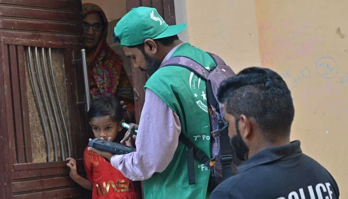 An enumerator obtains data from a household during the 7th census in Karachi on March 1, 2023. — AFP