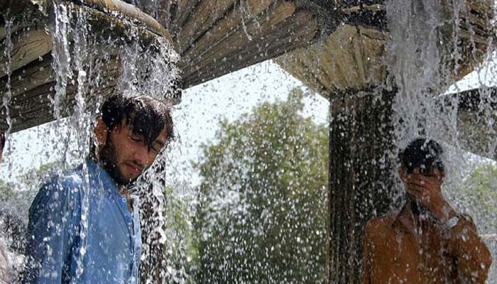 Pakistani residents cool off during an hot summer day in Karachi. — AFP/File