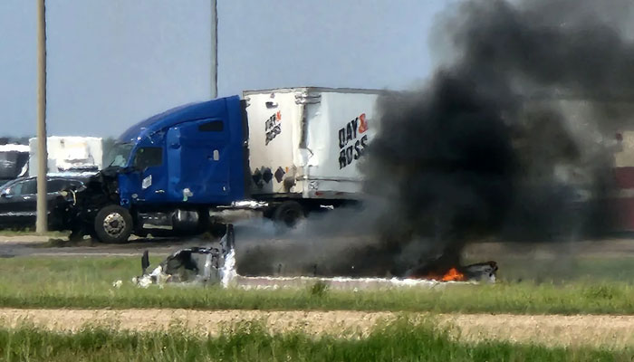 Smoke comes out of a car following a road accident that left 15 dead near Carberry, west of Winnipeg, Canada, on Thursday. AFP