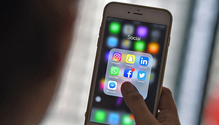 A woman looks at social networking applications Facebook, Instagram, Snapchat, Whatsapp, Twitter and Messenger on a smartphone in Kuala Lumpur, Malaysia, on March 22, 2018. — AFP