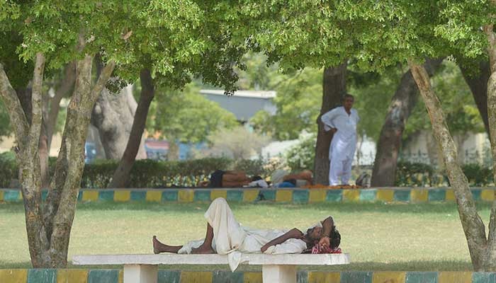 A Pakistani man rests under the shade of trees during a heatwave in Karachi, Pakistan, on June 23, 2015. — AFP