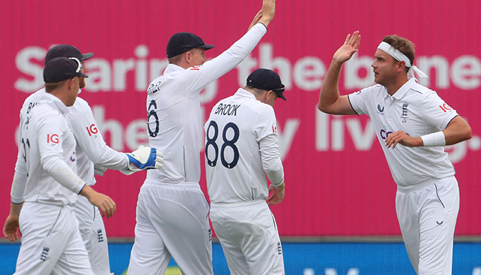 England´s Stuart Broad (3R) celebrates with England´s James Anderson (L) after bowling Australia´s David Warner during play on day two of the first Ashes cricket Test match between England and Australia at Edgbaston in Birmingham, central England on June 17, 2023.—AFP