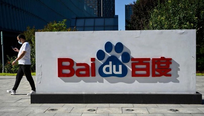 A man walks by a Baidu logo displayed outside the company headquarters in Beijing, China. — AFP/File