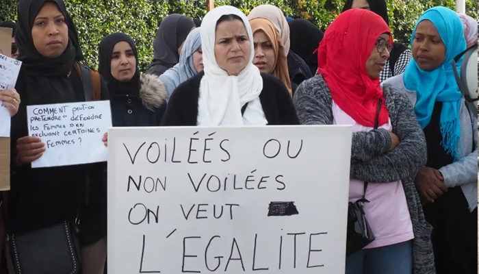 Protesters hold a placard reading Veiled or not veiled, we want equality as they take part in a demonstration in Perpignan, southwestern France. — AFP/File