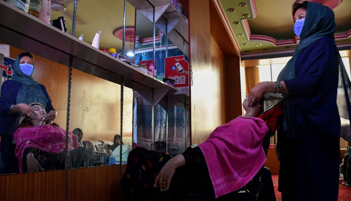 An Afghan beautician attends a customer at a beauty salon. — AFP/File