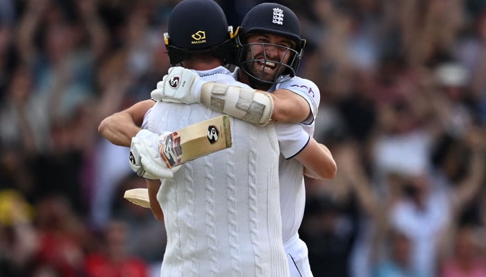 England´s Mark Wood (R) celebrates with England´s Chris Woakes (L) after Woakes hits a boundary to win the test match on day four of the third Ashes cricket Test match between England and Australia at Headingley cricket ground in Leeds, northern England on July 9, 2023. — AFP