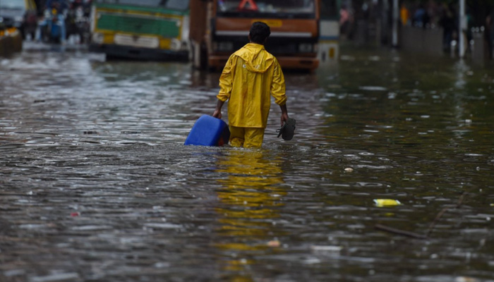 A man wades through rain water submerging a road in India in this undated image. — AFP/File