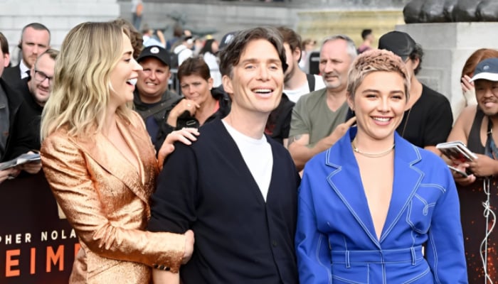 Cillian Murphy posing between co-stars Florence Pugh and Emily Blunt