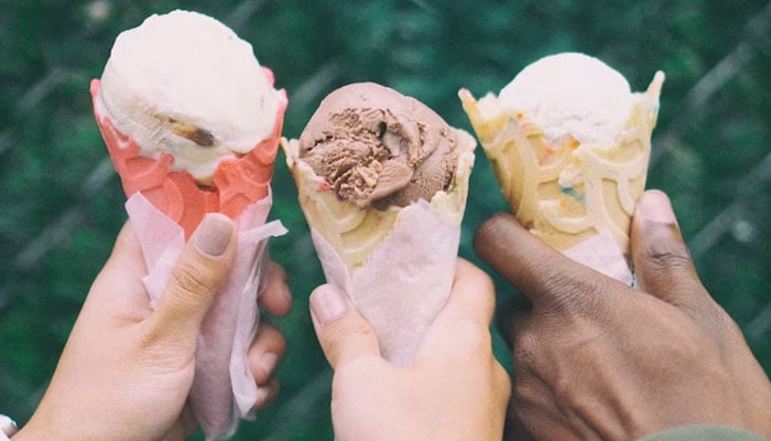 This picture shows individuals holding ice cream cones. — Unsplash/File