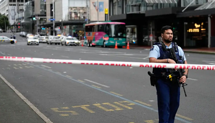 Silahlı bir Yeni Zelanda polis memuru, Perşembe sabahı Auckland, Yeni Zelanda'da bir silahlı çatışmanın ardından merkezi iş bölgesinde bir barikatta duruyor.- Associated Press