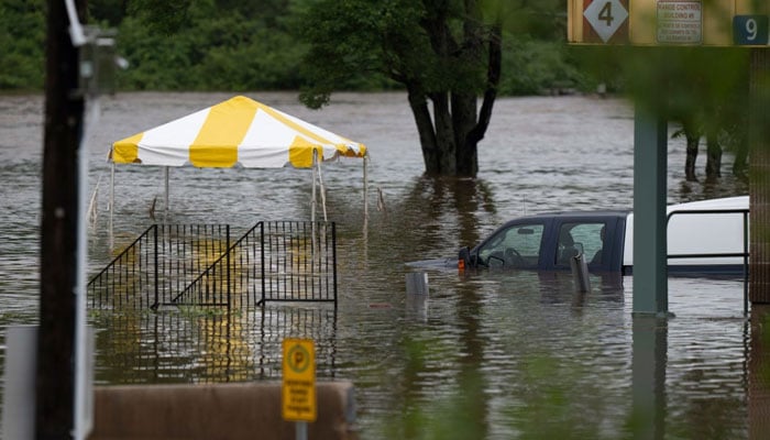 This image shows a vehicle stuck in the middle of a flooded street due to three months worth of rainfall in Nova Scotia, Canada. — Twitter/@SAFExcellence