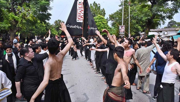 Mourners are beating themselves during the main procession of 9th Muharram at G-6 Road in Islamabad on July 28, 2023. — APP