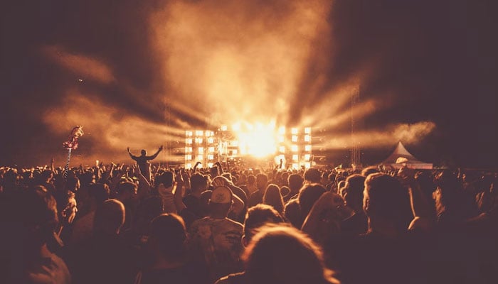 This representational picture shows a crowd watching an artist performing stage during a festival. — Unsplash/File