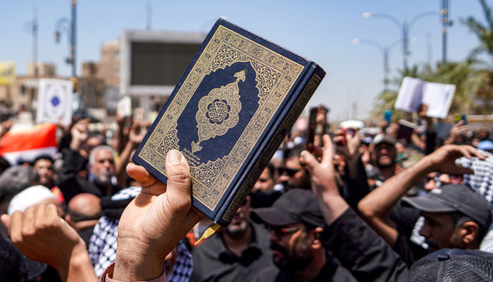 A man holds up a copy of the Holy Quran amid protests against incidents of desecration of the holy book. — AFP/File