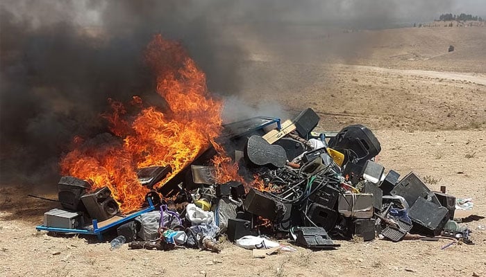 This photograph taken on July 29, 2023, shows a pile of musical instruments and equipments being set on fire by members of the Taliban on the outskirts of Herat. — AFP