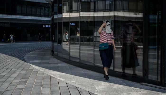 A woman wears a face covering for protection from the sun in Beijing on Wednesday. AFP/File