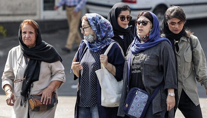 In this file photo from September 26, 2022, women wearing head coverings walk along a street in the center of Irans capital Tehran. — AFP