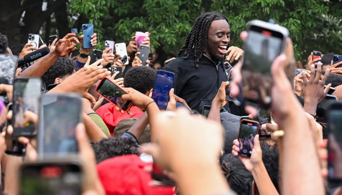 Twitch streamer Kai Cenat, centre, is surrounded by fans in New York on Friday. AFP