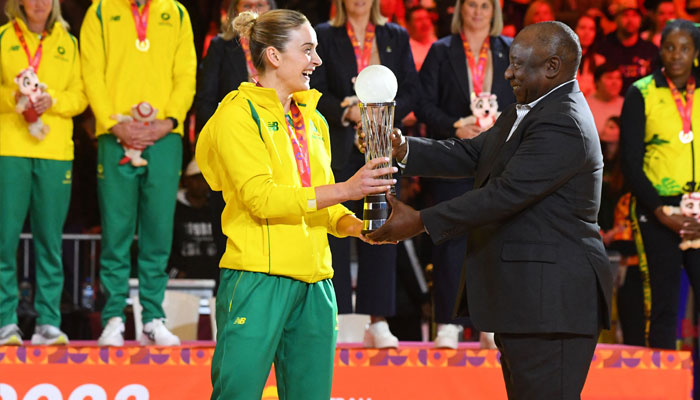 South African Presiden Cyril Ramaphosa(R), presents Liz Watson, captain of the Australian team, with the Netball World Cup trophy, in Cape Town on 06 August 2023.—AFP