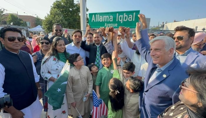 People hold up the sign Allama Iqbal Avenue in Queens, New York. — Pakistani Embassy in Washington