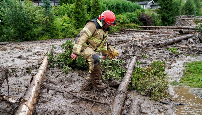 A firefighter wades through mud following a landslide in Valdres, Nord Aurdal, near Bagn, Norway on August 8, 2023, as extreme weather ´Hans´ has hit eastern Norway. — AFP