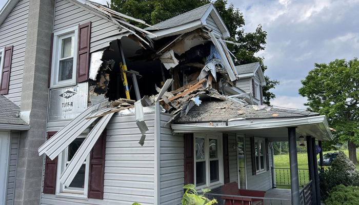 A house can be seen where a car was smashed into the second floor in Lewistown Pennsylvania in this picture released on August 7, 2023. — Facebook/Junction Fire Compan