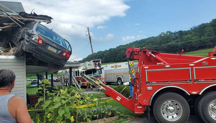 A car can be seen smashed into the second floor of a house in Lewistown Pennsylvania in this picture released on August 7, 2023. — Facebook/Junction Fire Company