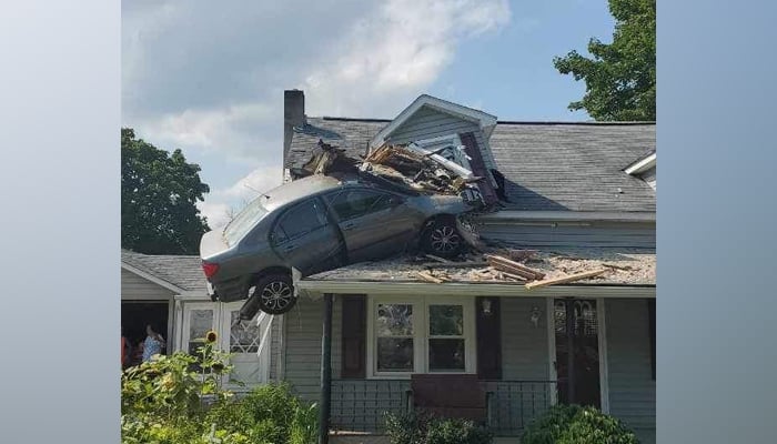 A car can be seen smashed into the second floor of a house in Lewistown Pennsylvania in this picture released on August 7, 2023. — Facebook/Junction Fire Company