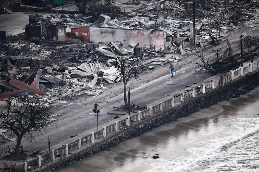 A person walking down Front Street past destroyed buildings burned to the ground in Lahaina in the aftermath of wildfires in western Maui, Hawaii. — AFP/File