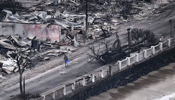 An aerial image taken on August 10, 2023, shows a person walking past buildings burned to the ground in Lahaina in western Maui, Hawaii. Newsweek