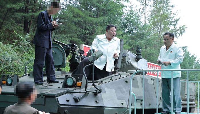 This photo released from North Koreas official Korean Central News Agency (KCNA) on August 14, 2023 shows North Korea´s leader Kim Jong Un (C) on a multi-purpose armoured vehicle after a visit to an important munitions factory at an undisclosed location in North Korea. — AFP