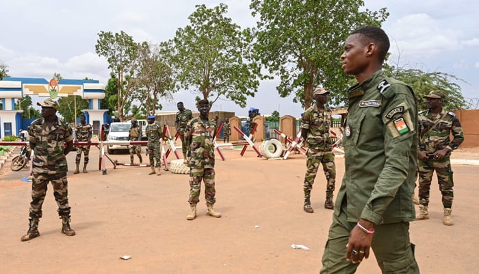 Nigerien soldiers stand guard as supporters of Nigers National Council for the Safeguard of the Homeland (CNSP) gather for a demonstration in Niamey on August 11, 2023, near a French airbase in Niger. — AFP