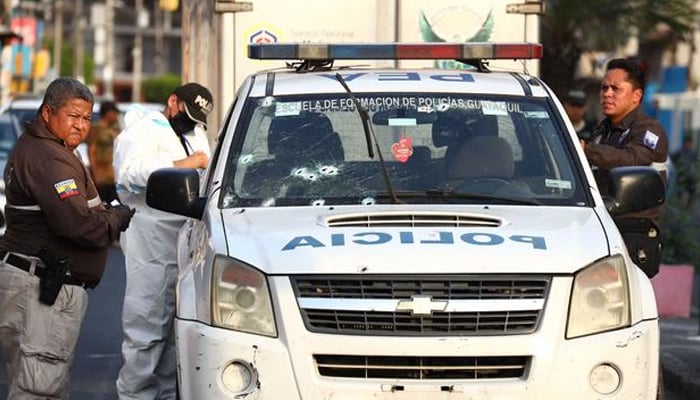 Ulusal polis memurları, 1 Kasım 2022'de Ekvador'un Duran kentinde bir devriye arabasına düzenlenen saldırının olay yerinde çalışıyor. — AFP