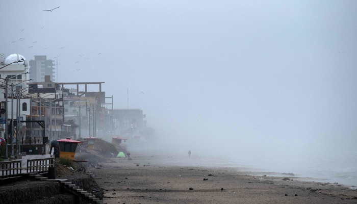 A man walks on the beach as tropical storm Hilary approaches near the US-Mexico border in Playas de Tijuana, Baja California State, Mexico, on August 20, 2023. — AFP