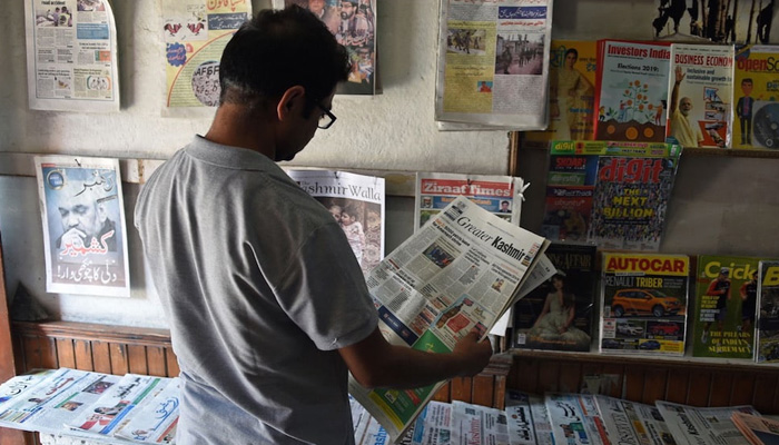 A man reads a newspaper at a stall where “The Kashmir Walla” and other publications are displayed, in Srinagar, 3 July 2019. — AFP