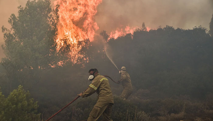 Firefighters battle flames during a wildfire near Prodromos on August 21, 2023.—AFP