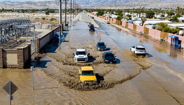 In this aerial picture taken on Aug. 21, 2023 vehicles drive through floodwaters following heavy rains from Tropical Storm Hilary in Thousand Palms, California. Tropical Storm Hilary drenched Southern California with record rainfall, shutting down schools, roads, and businesses before edging in on Nevada on Aug. 21, 2023. California Governor Gavin Newsom had declared a state of emergency over much of the typically dry area, where flash flood warnings remained in effect until this morning. AFP