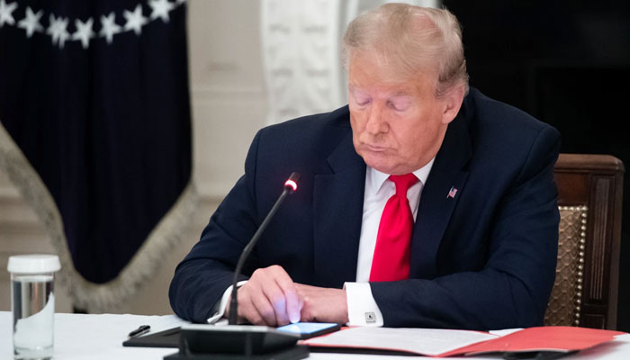 Donald Trump using his phone during a meeting at the White House in 2020. — AFP/File