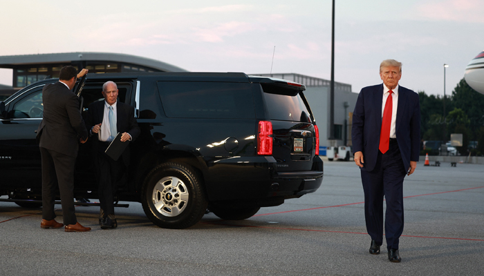 Former US President Donald Trump and his lawyer, Steven Sadow (L), arrive at Atlanta Hartsfield-Jackson International Airport after being booked at the Fulton County jail on August 24, 2023, in Atlanta, Georgia. — AFP