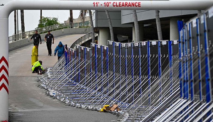 Workers set up a fence to prevent flooding at Tampa General Hospital in Tampa, Florida, on August 29, 2023 as the city prepares for Hurricane Idalia. — AFP