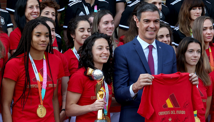 Spains acting Prime Minister Pedro Sanchez (R) holds the Spain womens national football teams jersey as he poses with midfielder Jenni Hermoso (TOP L) and teammates after their 2023 World Cup victory in Sydney, at La Moncloa Palace in Madrid on August 22, 2023. — AFP