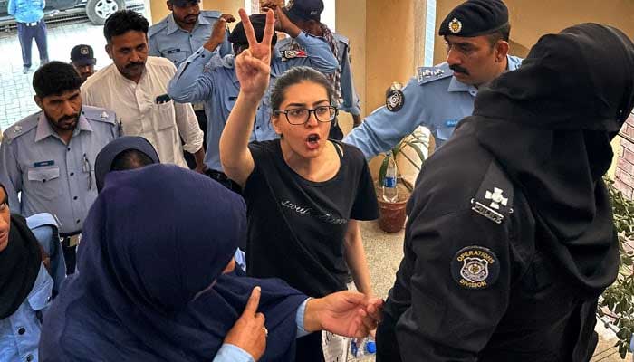 Police officials presents arrested lawyer and human rights activist Imaan Mazari-Hazir (C) before a court in Islamabad on August 20, 2023. —  AFP