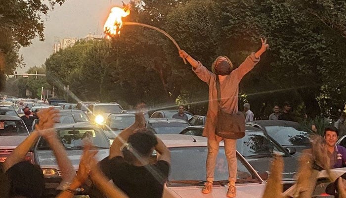 A woman protester burning hijab to protest the death of Jina Mahsa Amini in Iran. — AFP