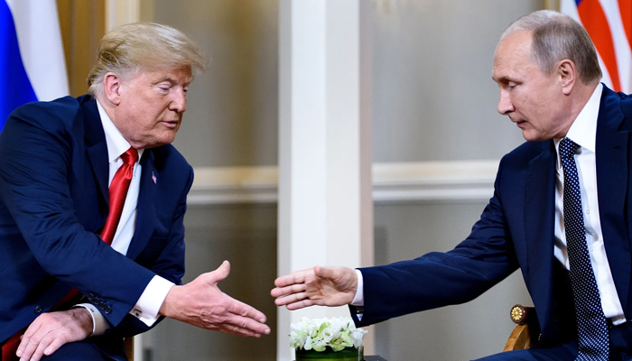 The then US President Donald Trump (left) while leaning forward to shake hands with the Russian President Vladimir Putin as he is also gesturing the same in Helsinki. — AFP/File