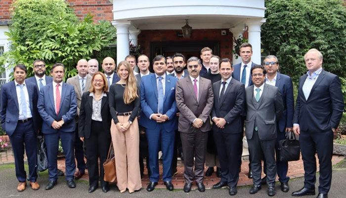 İngiliz yatırımcılar Londra'daki Pakistan Evi'nde Bekçi Başbakan Anwaar-ul-Haq Kakar ile fotoğraf çektiriyor.  —PID