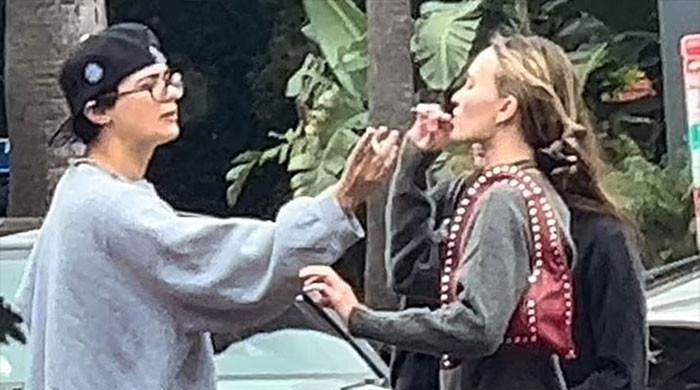 Lily-Rose Depp کو ٹھنڈے کندھے کے اوپر دوستوں کے ساتھ دھواں اٹھاتے دیکھا