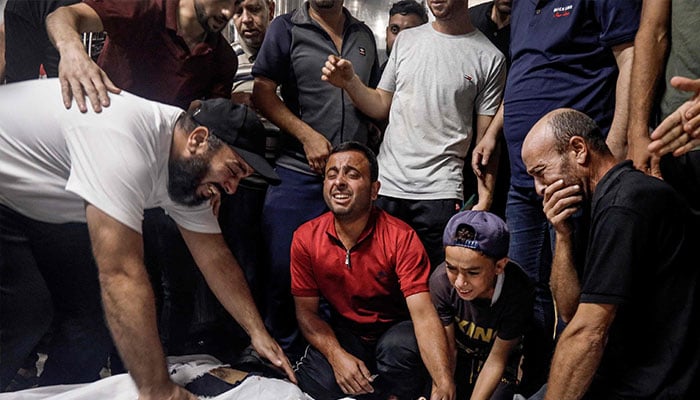 Family members and relatives mourn over the bodies of Palestinian fighters killed in the latest inflitration operation into Israel, at the mortuary of a hospital in Gaza City on October 7, 2023. — AFP