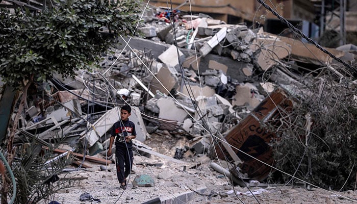 A young boy walks amid the rubble of a building destroyed by Israeli air strikes in Gaza City on October 7, 2023. — AFP