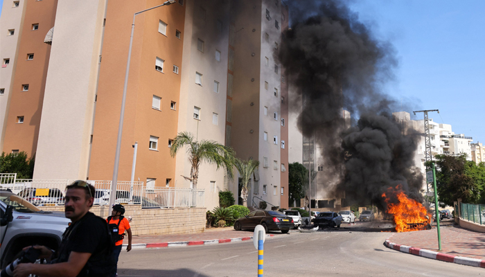 A car is seen on fire following a rocket attack from the Gaza Strip in Ashkelon, southern Israel, on October 7, 2023. — AFP