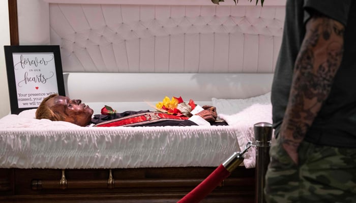 Visitors look at the body of Stoneman Willie, a jailed thief who died in a Pennsylvania prison in 1895 and was accidentally mummified by undertakers, lies on display at the local funeral home in Reading, Pennsylvania on October 6, 2023. — AFP